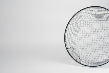 Close-up of a round metallic mesh basket or sieve on a clean white background. Ideal for kitchen, cooking, filtration, or industrial texture.