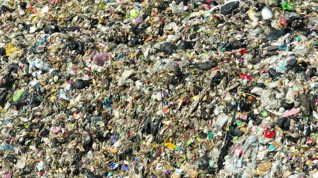 Overhead view of scattered trash illustrating pollution intensity, ecological damage, consumer overuse, ineffective waste handling, and the call for stronger sustainability awareness.
