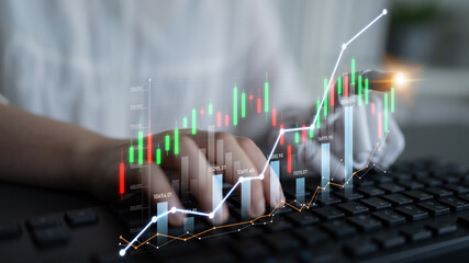 A close-up of hands on a keyboard with a financial graph overlay displays stock market trends in a modern workspace, emphasizing investment and analysis. Scalp