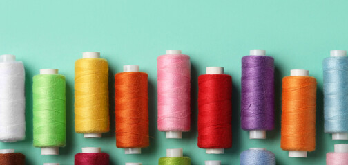 Set of different thread spools on mint background, closeup