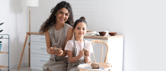 Little girl with her mother making ceramic pot at home