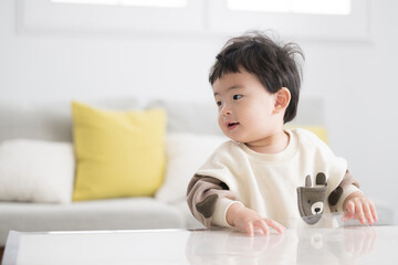 Fototapeta premium つかまり立ちをする赤ちゃん