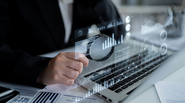 A businessman analyzes data on a laptop, interacting with digital charts and graphs. This modern office scene highlights the importance of strategic decision-making and data analysis. Scalp - Powered by Adobe