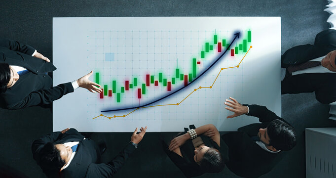 Business professionals gather around a table to analyze financial charts and graphs, discussing trends, strategies, and decisions in a modern office setting. Axiom - Powered by Adobe