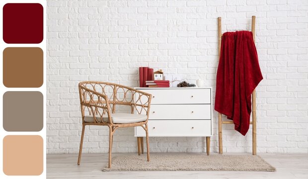 Armchair, chest of drawers with books and red plaid on ladder near white brick wall. Different color patterns