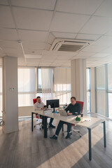 Two Caucasian men working in an office. 