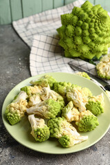 Plate with baby romanesco cabbage on grey grunge table