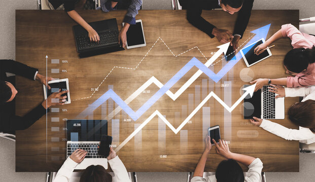Aerial view of business meeting with multiple digital devices and growth graph. Team members engage in collaborative analysis to foster success in a corporate setting. Scalp - Powered by Adobe