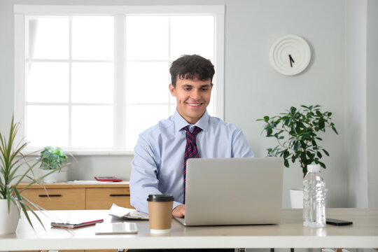 Male accountant working with modern laptop at workplace in office