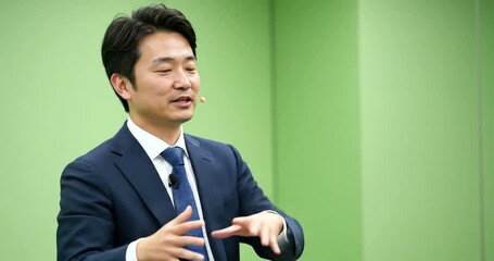 Asian businessman in a suit speaking animatedly with his hands. - Powered by Adobe