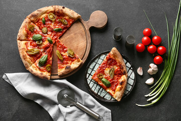 Composition with tasty pizza and cutter on dark background