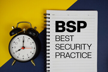 BSP Best Security Practice text written on notepad with alarm clock on yellow background