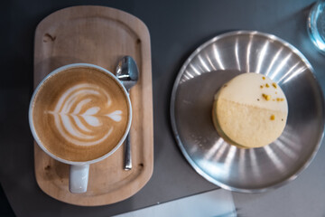 Close-up of a horizontal photo of a barista cafe focusing on a pistachio alfajor with white chocolate and orange juice in the background, cenital
