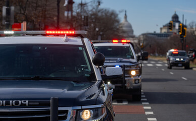 Fire hoses stretch across the road. Police cars hold position. Capitol looms behind the action. Emergency teams work fast. Public safety remains priority. © Volodymyr