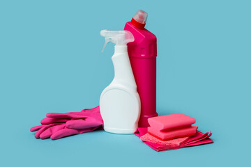 Bottles of mold remover, sponge and rags on blue background