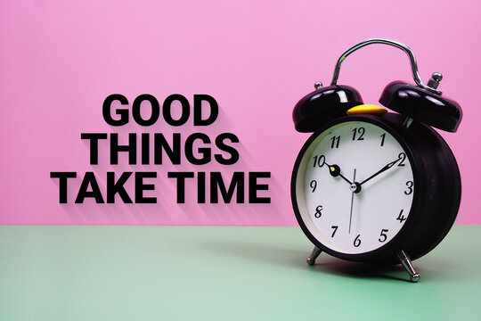 Black alarm clock on a pastel green and pink background with the text "Good Things Take Time"