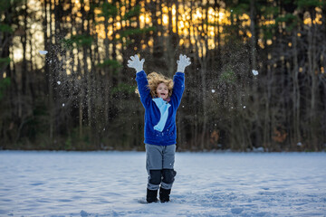 Child playing in winter. Kid enjoying fresh snow. Winter child close-up face. Christmas greeting...