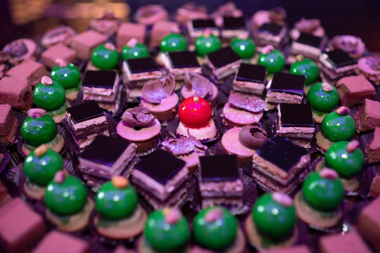 Colorful macarons and desserts on elegant buffet table. Luxury sweets and desserts served at festive event. Delicious macarons. Dessert table with pastries. Sweet dessert. French pastries.