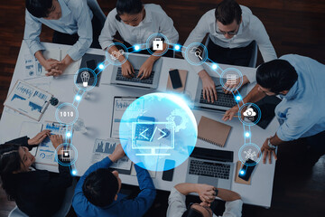 A diverse team of professionals engages in a collaborative meeting on technology projects, utilizing laptops and visual data, emphasizing innovation and strategy development. Trope