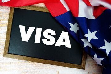 American flag with blackboard "VISA" on wooden background
