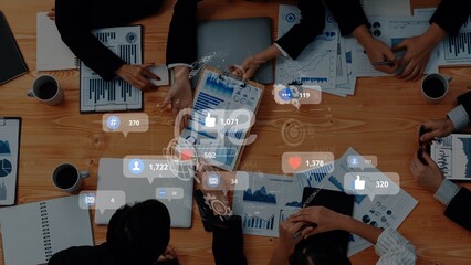 Overhead view of a diverse team working collaboratively in a modern office setting, sharing insights through digital devices and discussing key performance metrics. Raster