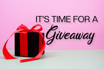 It's Time For A Giveaway text with gift box present on pink and green background
