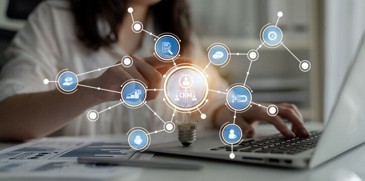 A businesswoman interacts with a laptop in a modern workspace, showcasing connections between technology and data, symbolizing innovation and strategic growth. Crux - Powered by Adobe