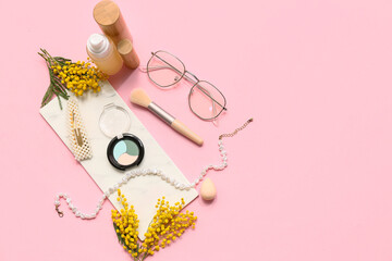Decorative cosmetics with stylish accessories and mimosa flowers on pink background