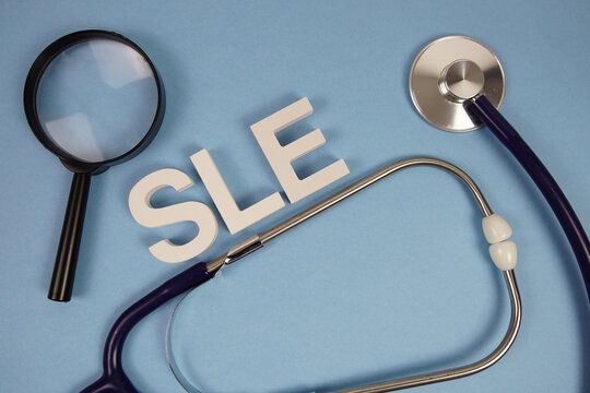 SLE Systemic Lupus Erythematosus text with stethoscope on blue background