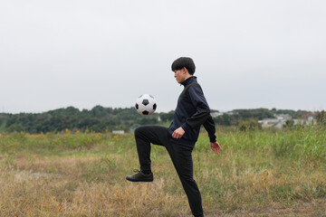 サッカーのリフティングを練習する男性のサイドショット