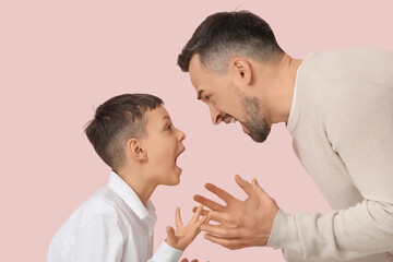 Angry father with his son squabbling on pink background