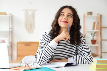 Thoughtful female Indian student studying at home