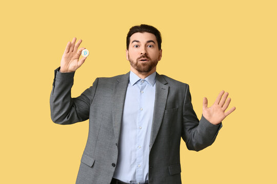 Shocked businessman with bitcoin on yellow background - Powered by Adobe