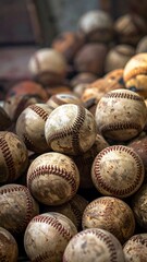 A close-up shot showcasing a pile of well-worn baseballs. The spheres, showing aged textures and stitching, are stacked together