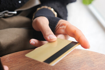 Obraz premium Hand holding a gold card at a casual setting
