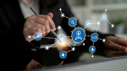 Business professional analyzes customer relationship management concepts with digital technology and connection icons on sleek touchscreen interface. Tessel.