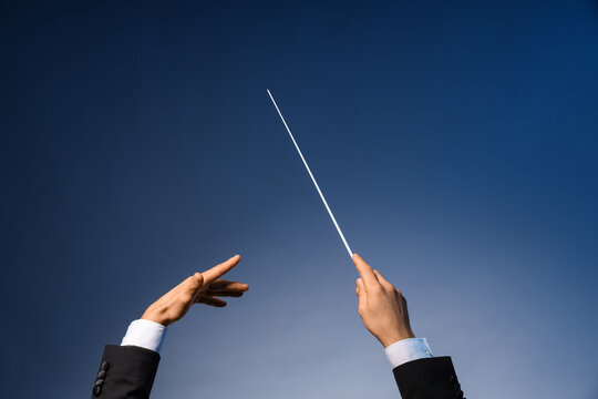 Hands of male conductor on blue background