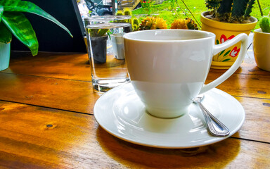 Glass cup of americano black coffee with spoon and plate.
