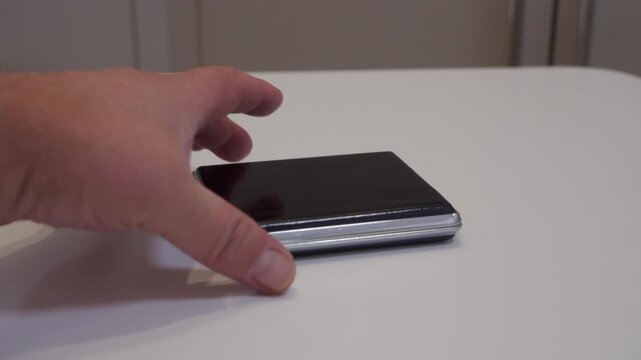 A metal cigarette case is placed onto a table. This action creates a sharp clack.