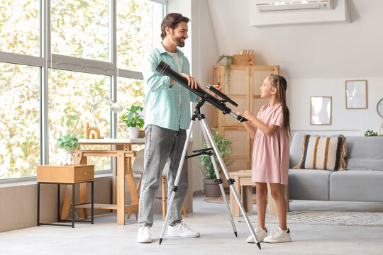 Little girl with her father and telescope at home - Powered by Adobe