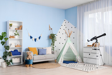 Interior of stylish children's room with sofa, teepee and modern telescope near window