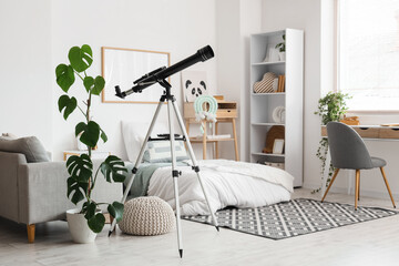 Fototapeta premium Interior of stylish children's room with bed, table and modern telescope