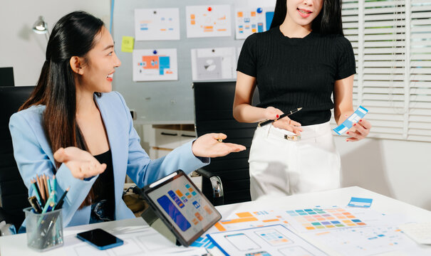 Two UX UI designers brainstorming mobile app wireframes in a modern startup office, showcasing creative teamwork, digital design - Powered by Adobe
