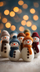 Mini snowmen with golden bokeh and text space vertical