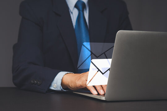 Businessman using laptop for email communication.
