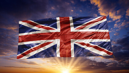 Union Jack Flag Waving on a Pole Against a Dramatic Sunset Sky Background.