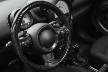 View of black steering wheel in modern car, closeup