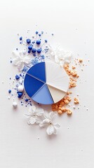 A vibrant composition featuring a pie chart divided into sections of blue, white, and beige, surrounded by scattered blue and orange pigments, small white berri