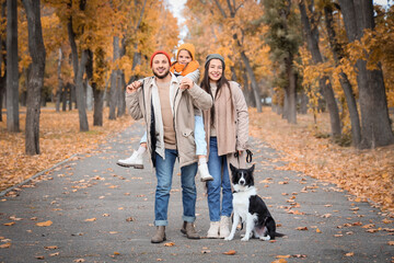 Happy family with dog in autumn park