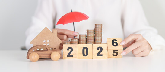 2025 end year to Happy New Year 2026 with red umbrella over money stack. Insurance, real estate, Home, car, loan, tax, investment, mortgage, financial, savings, protection and safety